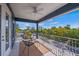 Comfortable balcony showcasing a seating area, neutral tones, landscaping views, and a ceiling fan at 159 Crescent Dr, Anna Maria, FL 34216