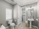 Light-filled bathroom features a toilet, pedestal sink, vanity mirror, and tiled walk-in shower at 159 Crescent Dr, Anna Maria, FL 34216
