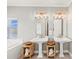 Bright bathroom with double sinks, mirrors and a luxurious tub next to windows for natural light at 159 Crescent Dr, Anna Maria, FL 34216