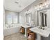 Bright bathroom with double sinks, mirrors and a luxurious tub next to windows for natural light at 159 Crescent Dr, Anna Maria, FL 34216
