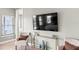 Bright bedroom featuring light tile flooring, neutral paint, and a flatscreen television at 159 Crescent Dr, Anna Maria, FL 34216