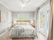 Cozy bedroom with a queen bed, neutral tones, ceiling fan, and access to the balcony through the French doors at 159 Crescent Dr, Anna Maria, FL 34216