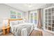 Bright bedroom featuring a ceiling fan, french doors to a balcony, and a queen-sized bed with neutral linens at 159 Crescent Dr, Anna Maria, FL 34216