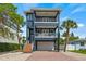 Three-story home featuring dual balconies, and lush landscaping at 159 Crescent Dr, Anna Maria, FL 34216