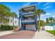 Beautiful three-story home with balconies, modern architecture, and a brick driveway at 159 Crescent Dr, Anna Maria, FL 34216