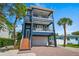 Stunning three-story home featuring dual balconies and a brick-paved driveway at 159 Crescent Dr, Anna Maria, FL 34216