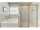Bright bathroom showcasing separate soaking tub and glass enclosed shower at 17555 Cantarina Cv, Bradenton, FL 34211