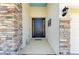 Elegant front entrance with a decorative stone column and a dark-colored front door at 17555 Cantarina Cv, Bradenton, FL 34211