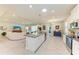 Bright, open-concept with white cabinets, granite countertops, and stainless appliances, flowing into the living room at 17555 Cantarina Cv, Bradenton, FL 34211