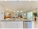 Granite countertop island with bar seating overlooks the adjacent dining and living areas, providing seamless transitions at 17555 Cantarina Cv, Bradenton, FL 34211