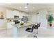 Well-equipped kitchen with stainless appliances, granite countertops, island with bar seating, and stylish pendant lighting at 17555 Cantarina Cv, Bradenton, FL 34211