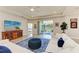 Bright living room with comfortable seating, tray ceiling, large sliding glass doors to patio, and water view at 17555 Cantarina Cv, Bradenton, FL 34211
