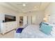 Bright main bedroom showcasing a ceiling fan, carpeted floors, a television, and access to the main bathroom at 17555 Cantarina Cv, Bradenton, FL 34211