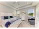 Bright, airy main bedroom featuring a tray ceiling, serene lake views and soothing neutral décor at 17555 Cantarina Cv, Bradenton, FL 34211