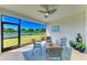Relaxing screened lanai featuring scenic lake views and a cozy seating arrangement with blue accents at 17555 Cantarina Cv, Bradenton, FL 34211