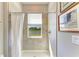 Bright tiled shower features a window overlooking the green landscape and a lake at 17555 Cantarina Cv, Bradenton, FL 34211
