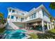 Resort style backyard features a sparkling pool, covered patio with seating, and multiple balconies at 205 17Th N St, Bradenton Beach, FL 34217