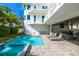Backyard features a sparkling pool, covered patio with seating, lounge chairs, and manicured lawn at 205 17Th N St, Bradenton Beach, FL 34217