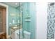 Modern bathroom features a glass shower with blue accents, granite counters, and coastal decor at 205 17Th N St, Bradenton Beach, FL 34217