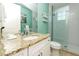 Bathroom featuring granite counters, coastal decor, and a glass shower with blue accents at 205 17Th N St, Bradenton Beach, FL 34217
