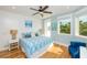 Bright bedroom featuring a ceiling fan, coastal decor, and an ensuite bathroom with natural lighting at 205 17Th N St, Bradenton Beach, FL 34217