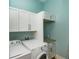Bright laundry room features modern washer, dryer, and white cabinets for ample storage at 205 17Th N St, Bradenton Beach, FL 34217