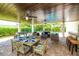 Covered patio with an outdoor dining set, living area, and game table provides an inviting entertaining space at 205 17Th N St, Bradenton Beach, FL 34217