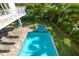 Aerial view of pool and spa, surrounded by manicured lawn, greenery, and lounge seating creating a private oasis at 205 17Th N St, Bradenton Beach, FL 34217