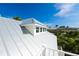 Close up of the modern metal roof and dormer windows, offering neighborhood views and clear blue skies at 205 17Th N St, Bradenton Beach, FL 34217