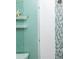 Close up of modern walk in shower with custom tile and glass doors with blue accents and coastal decor at 205 17Th N St, Bradenton Beach, FL 34217