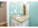 Bathroom vanity with granite counters, a framed mirror, coastal decor, and overhead lighting at 205 17Th N St, Bradenton Beach, FL 34217