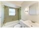 Well-lit bathroom features a shower over bath and vanity with bright wall lighting at 2121 Pueblo Cir # V6, Sarasota, FL 34231