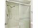 Bathroom features a frosted sliding door shower, safety bar, and neutral-color ceramic tile at 2121 Pueblo Cir # V6, Sarasota, FL 34231