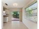 Dining room area with tiled floors, sliding glass doors overlooking a landscaped backyard, and a kitchen counter at 2121 Pueblo Cir # V6, Sarasota, FL 34231
