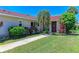 Charming home featuring a beautiful red tile roof, lush tropical landscaping, and a well-maintained lawn at 2121 Pueblo Cir # V6, Sarasota, FL 34231