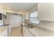A full kitchen view with stainless steel appliances, granite countertops, white cabinets, tile floor and a pantry at 2121 Pueblo Cir # V6, Sarasota, FL 34231