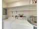 Functional laundry room with washer, dryer, storage shelves, and water heater at 2121 Pueblo Cir # V6, Sarasota, FL 34231