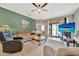 Inviting living room with comfortable seating, a ceiling fan, and sliding glass doors for natural light at 213 Babbling Brook Run, Bradenton, FL 34212