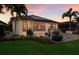 Outdoor patio with palm trees, seating, and solar panels on the roof at sunset at 2397 Vaccaro Dr, Sarasota, FL 34231