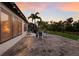 Relaxing backyard patio with furniture and landscaped lawn featuring a picturesque sunset view at 2397 Vaccaro Dr, Sarasota, FL 34231