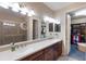 Elegant bathroom featuring dual sinks, a walk-in shower, and a glimpse into the spacious walk-in closet at 2397 Vaccaro Dr, Sarasota, FL 34231