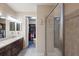 Elegant bathroom featuring dual sinks, a walk-in shower, and a glimpse into the spacious walk-in closet at 2397 Vaccaro Dr, Sarasota, FL 34231