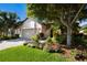 Charming single-story home with a paver driveway, lush landscaping, an American flag, and a two-car garage at 2397 Vaccaro Dr, Sarasota, FL 34231