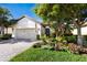 Charming home featuring a two-car garage, beautiful landscaping, and a brick-paved walkway to the front door at 2397 Vaccaro Dr, Sarasota, FL 34231