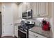 Modern kitchen with stainless steel appliances, granite countertops, and white cabinetry at 2397 Vaccaro Dr, Sarasota, FL 34231