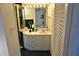 Bathroom vanity features a framed mirror and modern light fixture at 2763 Woodgate Ln # 108, Sarasota, FL 34231