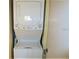 An efficient stackable white washer and dryer unit next to a white wall at 2763 Woodgate Ln # 108, Sarasota, FL 34231