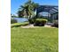 Lush lawn and landscaping lead up to an enclosed lanai and picturesque water view at 2980 Seasons Blvd, Sarasota, FL 34240