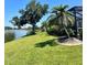 Backyard with lush lawn, mature trees and scenic lake views at 2980 Seasons Blvd, Sarasota, FL 34240