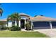 Single-story home with manicured front lawn, mature landscaping, decorative windows and a clay tile roof at 2980 Seasons Blvd, Sarasota, FL 34240